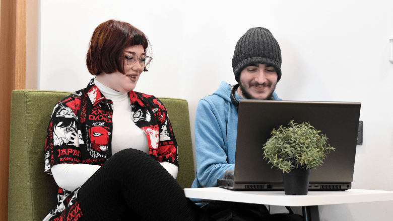 Female and male students working on a laptop together at the SCIoT Bletchley campus.